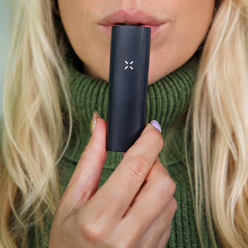 Woman in the process of using the Pax 4 vaporizer.