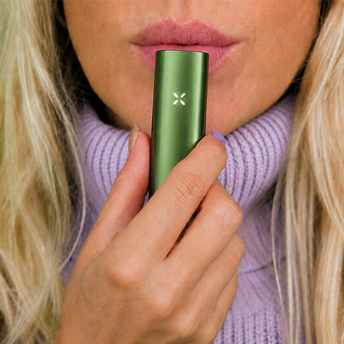 Woman in the process of using the Pax Flow vaporizer.