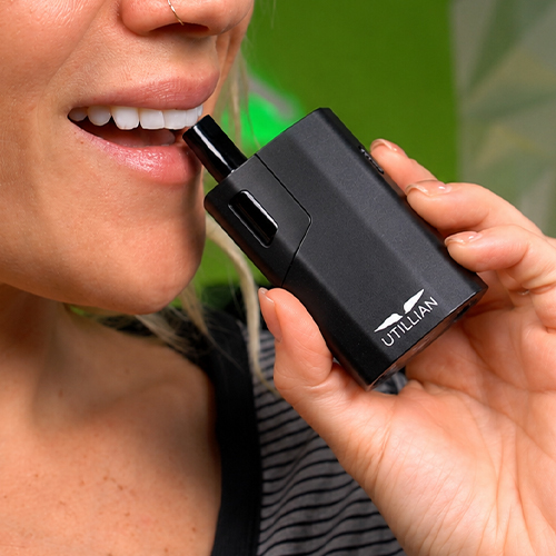 Woman in the process of using the Utillian 621 vaporizer.