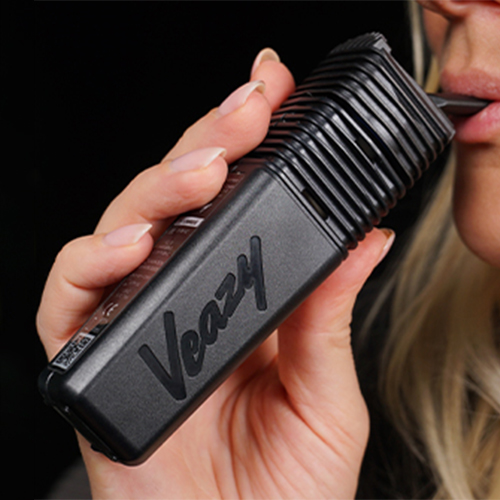Woman in the process of using the Veazy vaporizer.