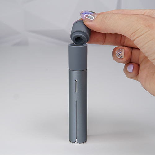 Puffco Pivot is on a table while a woman is attaching its extended mouthpiece.