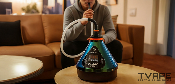 A man is inhaling from the Volcano Hybrid desktop vaporizer (Evergreen edition)
