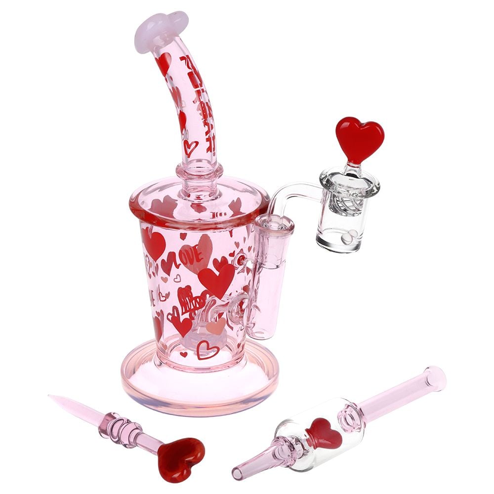 Pulsar Valentine’s Love Hearts Dab Rig Set in pink glass with red heart graphics, curved mouthpiece, quartz banger, dab tool, and matching dab straw.