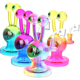 Four Snail Beastie Glass Dab Rigs in assorted bright colors, each with eye stalks, toothy mouth design, round base, and quartz banger.