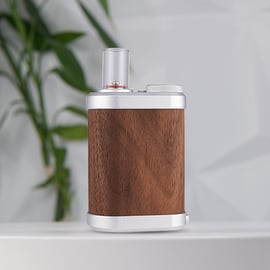 Tinymight 2 vaporizer with a sleek wooden body, metal accents, and a glass mouthpiece, set against a soft background.